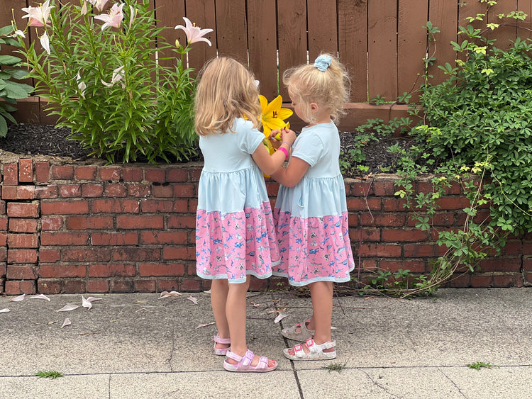 Girls wearing soft cotton summer twirl dresses with colorful prints outdoors