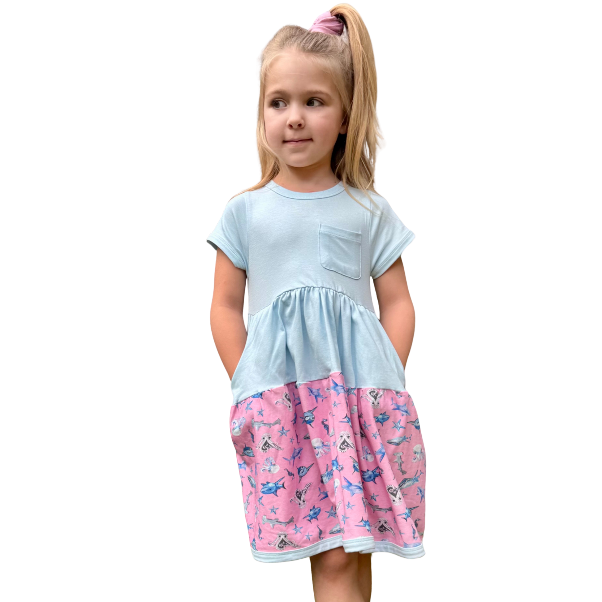 Girl age 5 in blue shark-print dress with scrunchie – twirl-friendly style made from soft, sensory-considerate fabric